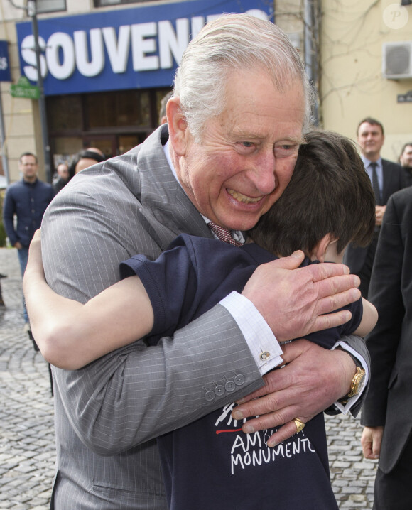 Le prince Charles, prince de Galles, prend dans ses bras Valentine Blacker, le fils de William Blacker, défenseur de l'environnement, pendant sa visite de la vieille ville à Bucarest, le 31 mars 2017.