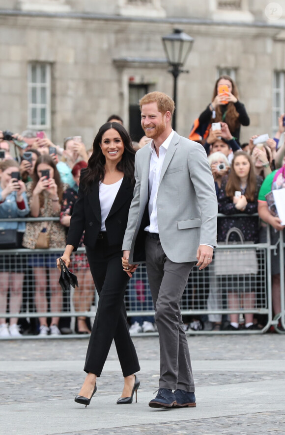 Le prince Harry, duc de Sussex et sa femme Meghan Markle, duchesse de Sussex saluent la foule lors de leur visite au collège de la trinité à Dublin le 11 juillet 2018.