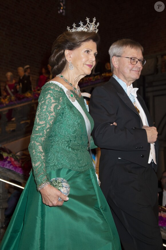 La reine Silvia de Suède au bras de Carl-Henrik Heldin (président du conseil d'administration de la Fondation Nobel) lors de la réception pour la cérémonie des Prix Nobel 2018, à l'hôtel de ville de Stockholm, le 10 décembre 2018.