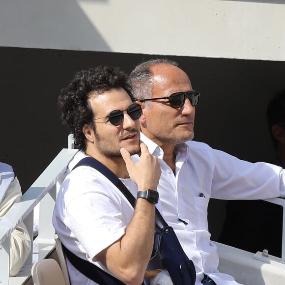 Amir Haddad (le bras gauche dans le plâtre après être tombé de scène pendant un concert à Aubagne) et son père René-Mikhael Haddad dans les tribunes des internationaux de tennis de Roland Garros à Paris, France, le 27 mai 2019. © Jacovides-Moreau/Bestimage