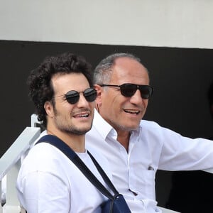 Amir Haddad (le bras gauche dans le plâtre après être tombé de scène pendant un concert à Aubagne) et son père René-Mikhael Haddad dans les tribunes des internationaux de tennis de Roland Garros à Paris, France, le 27 mai 2019. © Jacovides-Moreau/Bestimage