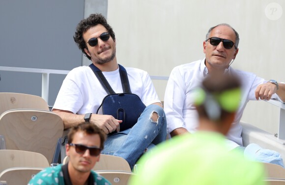 Amir Haddad (le bras gauche dans le plâtre après être tombé de scène pendant un concert à Aubagne) et son père René-Mikhael Haddad dans les tribunes des internationaux de tennis de Roland Garros à Paris, France, le 27 mai 2019. © Jacovides-Moreau/Bestimage