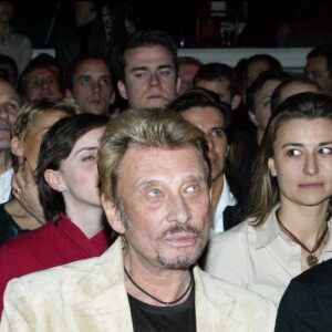 Laeticia et Johnny Hallyday et André Boudou lors de la remise du prix Humour et pub à l'Amnésia, le 25 mars 2004.