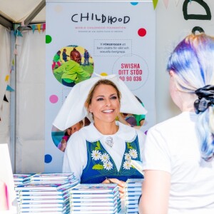 La princesse Madeleine de Suède en séance de dédicaces de son livre pour enfants Stella och hemligheten (Stella et le Secret) sur le parvis du palais royal à Stockholm, le 6 juin 2019, le jour de la Fête nationale.