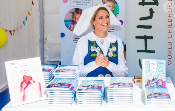 La princesse Madeleine de Suède en séance de dédicaces de son livre pour enfants Stella och hemligheten (Stella et le Secret) sur le parvis du palais royal à Stockholm, le 6 juin 2019, le jour de la Fête nationale.