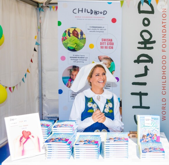 La princesse Madeleine de Suède en séance de dédicaces de son livre pour enfants Stella och hemligheten (Stella et le Secret) sur le parvis du palais royal à Stockholm, le 6 juin 2019, le jour de la Fête nationale.