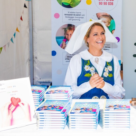 La princesse Madeleine de Suède en séance de dédicaces de son livre pour enfants Stella och hemligheten (Stella et le Secret) sur le parvis du palais royal à Stockholm, le 6 juin 2019, le jour de la Fête nationale.