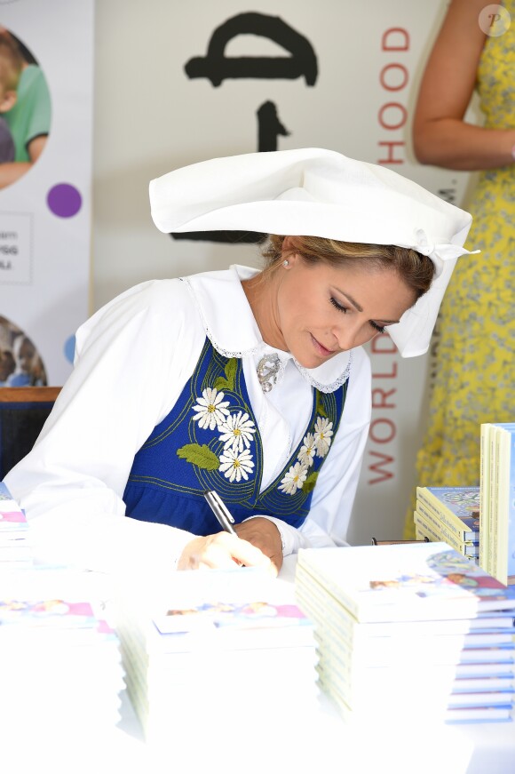 La princesse Madeleine de Suède en séance de dédicaces de son livre pour enfants Stella och hemligheten (Stella et le Secret) sur le parvis du palais royal à Stockholm, le 6 juin 2019, le jour de la Fête nationale.