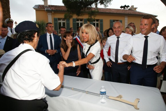 Emmanuel Macron, président de la République Française, et la première dame Brigitte Macron (avec une attelle au bras droit) arrivent à la mairie de Bormes-les-Mimosas où ils sont accueillis par François Arizzi (maire de Bormes-les-Mimosas) lors de la cérémonie de commémoration du 75ème anniversaire de la libération de la ville de Bormes-les-Mimosas, le 17 août 2019. © Dominique Jacovides/Bestimage
