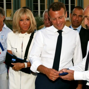 Emmanuel Macron, président de la République Française, et la première dame Brigitte Macron (avec une attelle au bras droit) arrivent à la mairie de Bormes-les-Mimosas où ils sont accueillis par François Arizzi (maire de Bormes-les-Mimosas) lors de la cérémonie de commémoration du 75ème anniversaire de la libération de la ville de Bormes-les-Mimosas, le 17 août 2019. © Dominique Jacovides/Bestimage