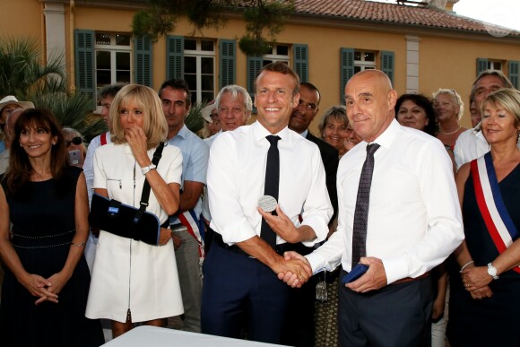 Emmanuel Macron, président de la République Française, et la première dame Brigitte Macron (avec une attelle au bras droit) arrivent à la mairie de Bormes-les-Mimosas où ils sont accueillis par François Arizzi (maire de Bormes-les-Mimosas) lors de la cérémonie de commémoration du 75ème anniversaire de la libération de la ville de Bormes-les-Mimosas, le 17 août 2019. © Dominique Jacovides/Bestimage
