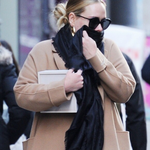 Exclusif - Adele se cache des photographes à la sortie d'un immeuble à New York, le 2 avril 2019.