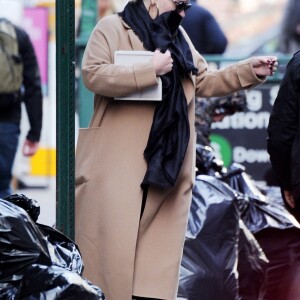 Exclusif - Adele se cache des photographes à la sortie d'un immeuble à New York, le 2 avril 2019.