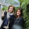 Valérie Trierweiler et Isabelle Chalençon tiennent un parapluie au village des Internationaux de France de tennis de Roland Garros à Paris le 4 juin 2014.