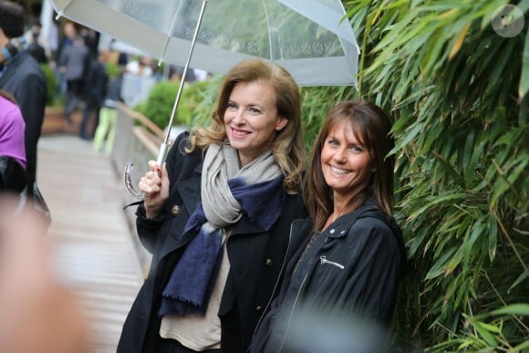 Valérie Trierweiler et Isabelle Chalençon tiennent un parapluie au village des Internationaux de France de tennis de Roland Garros à Paris le 4 juin 2014.