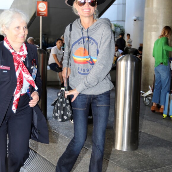 Laeticia Hallyday arrive à l'aéroport LAX de Los Angeles en provenance de Paris, accompagnée d'un agent Air France et d'un porteur, le 1er octobre 2019.