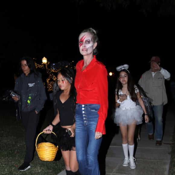 Laeticia Hallyday et sa fille Joy en pleine chasse aux bonbons dans le quartier de Pacific Palisades à Los Angeles pour Halloween, le 31 octobre 2019, en compagnie de Marilyne Issartier et d'Hortense d'Estève.