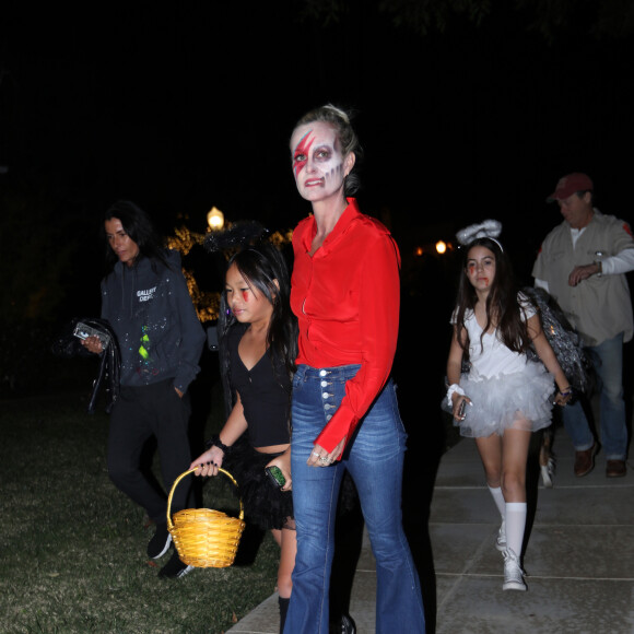 Laeticia Hallyday et sa fille Joy en pleine chasse aux bonbons dans le quartier de Pacific Palisades à Los Angeles pour Halloween, le 31 octobre 2019, en compagnie de Marilyne Issartier et d'Hortense d'Estève.