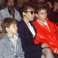 Véronique Colucci et ses fils Romain et Marius lors de l'enterrement de Coluche en 1986.