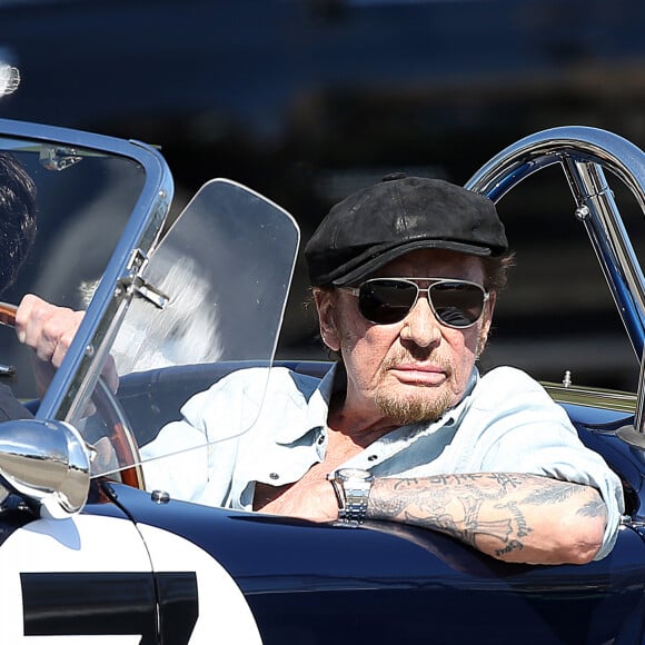 Johnny Hallyday accompagné de Maxim Nucci (Yodelice), arrive au restaurant "Soho House" à Malibu, au volant de son cabriolet AC Cobra marqué de son chiffre porte-bonheur, le numéro 7, Malibu, le 09 mars 2017.