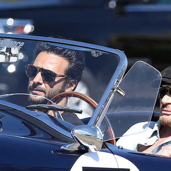 Johnny Hallyday accompagné de Maxim Nucci (Yodelice), arrive au restaurant "Soho House" à Malibu, au volant de son cabriolet AC Cobra marqué de son chiffre porte-bonheur, le numéro 7, Malibu, le 09 mars 2017.