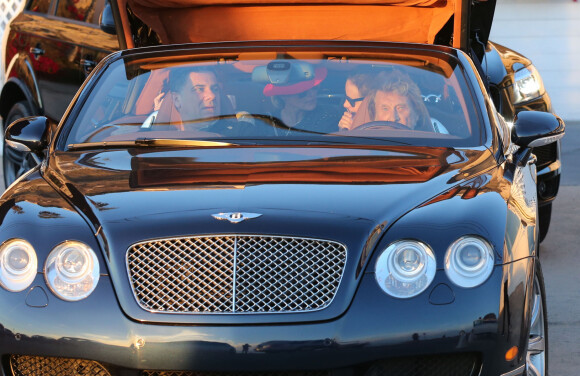 Johnny Hallyday en voiture avec Thierry Chassagne, le president de Warner Music France, la maison de disque du chanteur et sa femme Laeticia Hallyday à l'arriere à Malibu, le 9 novembre 2013.