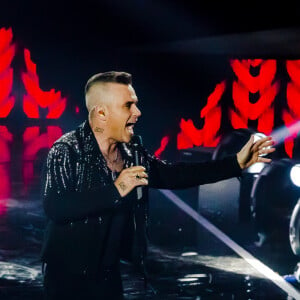 Robbie Williams et Lous and The Yakuza (Marie Pierra), stars de la finale de l'émission "X-Factor" en Italie. Milan. Le 12 décembre 2019. Robbie Williams a présenté un extrait de son album de Noël et a chanté avec les quatre finalistes du concours.