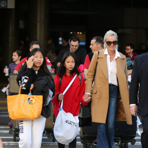 Exclusif - Laeticia Hallyday et ses filles Jade et Joy arrivent à l'aéroport LAX de Los Angeles en provenance de Paris, le samedi 11 janvier 2020 dans l'après-midi. Un chauffeur les attendait à leur arrivée. Laeticia lui fait signe, le salue, puis le suit en compagnie de ses filles jusqu'à la voiture. Deux porteurs poussent ses bagages