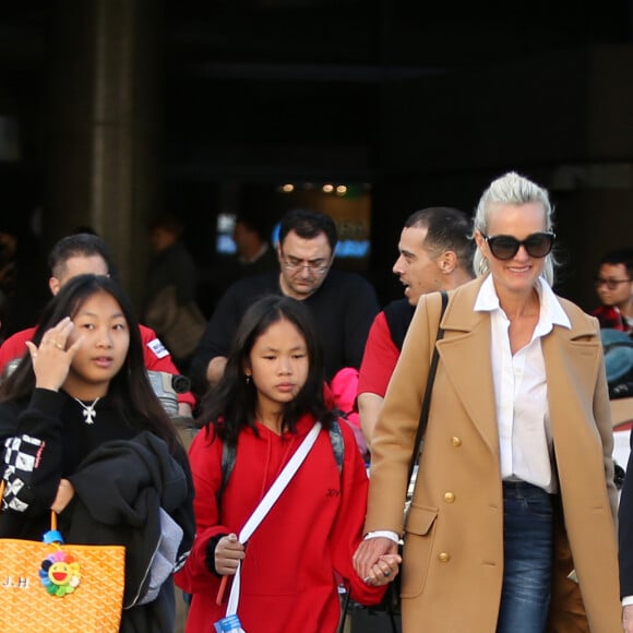 Exclusif - Laeticia Hallyday et ses filles Jade et Joy arrivent à l'aéroport LAX de Los Angeles en provenance de Paris, le samedi 11 janvier 2020 dans l'après-midi. Un chauffeur les attendait à leur arrivée. Laeticia lui fait signe, le salue, puis le suit en compagnie de ses filles jusqu'à la voiture. Deux porteurs poussent ses bagages