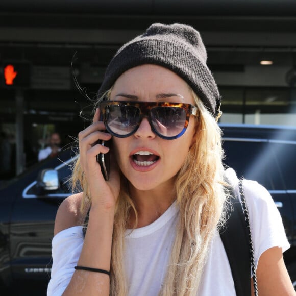 Amanda Bynes au téléphone à son arrivée à l'aéroport de Los Angeles, le 10 octobre 2014.