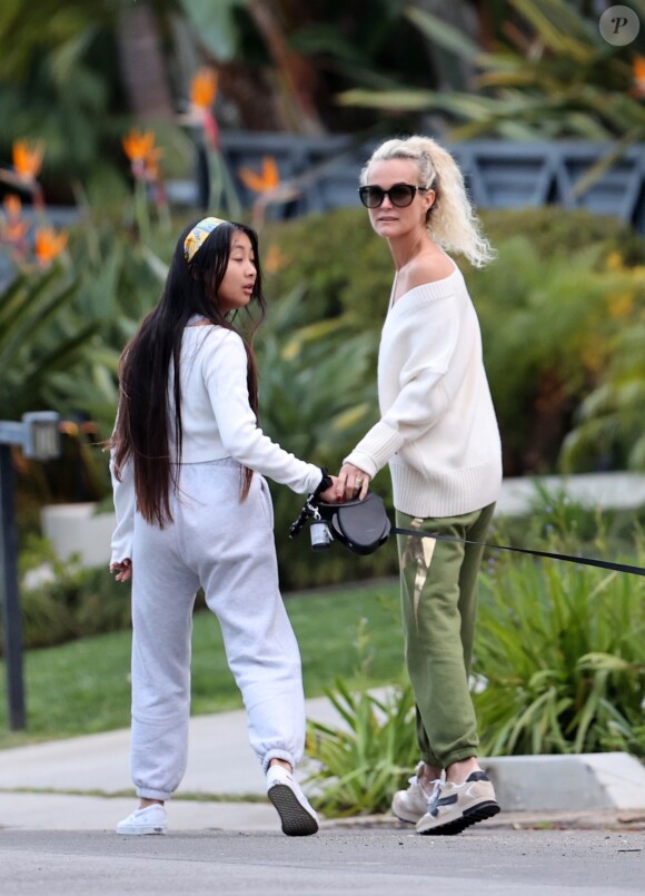 Laeticia Hallyday et ses filles Jade, 15 ans, et Joy, 11 ans, promènent leur chien Cheyenne dans le quartier de Brentwood à Los Angeles, pendant la période de confinement liée à l'épidémie de coronavirus (Covid-19), le 1er avril 2020.