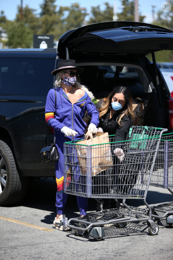 Première sortie pour Laeticia Hallyday depuis une semaine alors qu'elle est totalement confinée chez elle avec ses filles Jade et Joy, Maryline, Jean-Claude Sindres et sa femme Eléonore, pour aller faire ses courses au supermarché pour plusieurs jours à Los Angeles le 27 mars 2020.