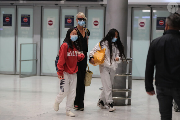 Laeticia Hallyday et ses filles Jade et Joy arrivent, avec des masques de protection contre l'épidémie de coronavirus (Covid-19), à l'aéroport de Paris-Charles-de-Gaulle à Roissy-en-France, France, le 18 juin 2020.