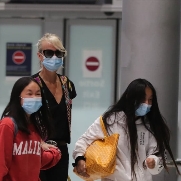 Laeticia Hallyday et ses filles Jade et Joy arrivent, avec des masques de protection contre l'épidémie de coronavirus (Covid-19), à l'aéroport de Paris-Charles-de-Gaulle à Roissy-en-France, France, le 18 juin 2020.