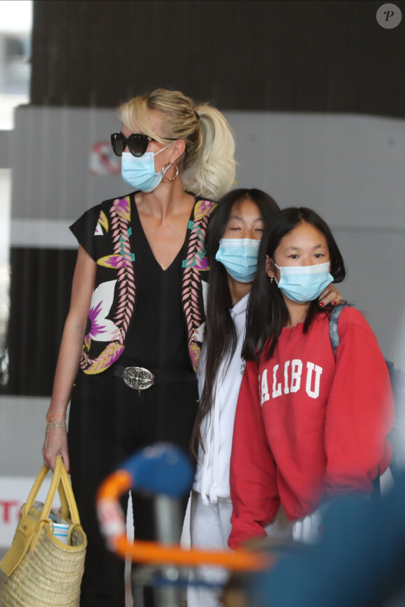 Laeticia Hallyday et ses filles Jade et Joy arrivent, avec des masques de protection contre l'épidémie de coronavirus (Covid-19), à l'aéroport de Paris-Charles-de-Gaulle à Roissy-en-France, France, le 18 juin 2020.