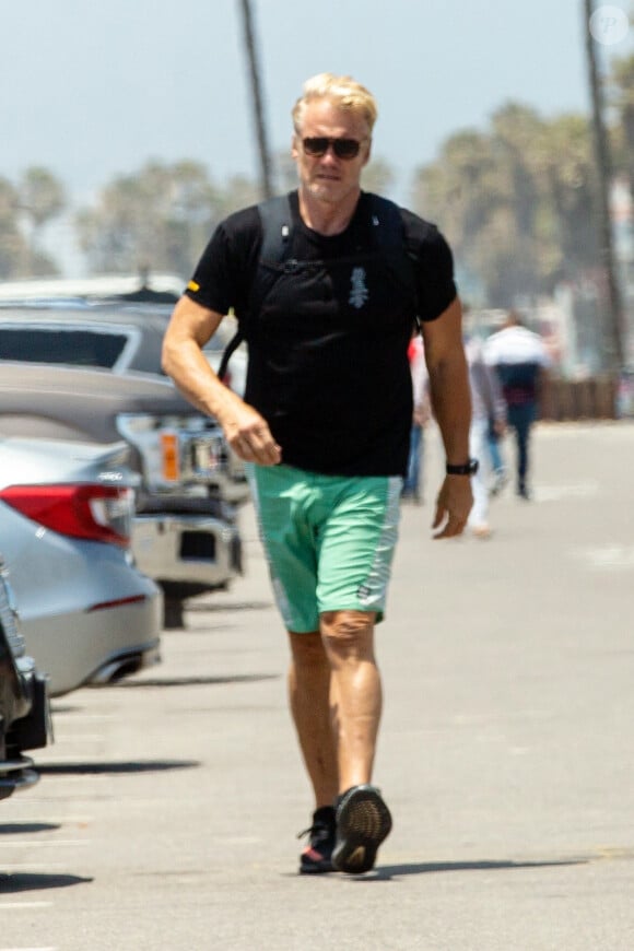 Exclusif - Dolph Lundgren se rafraîchit à Venice Beach, il joue avec une mystérieuse jeune femme blonde sur la plage. Los Angeles, le 28 juin 2019.