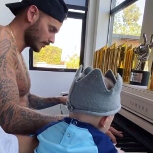 M. Pokora au piano avec son fils Isaiah. Le chanteur français est confiné à Los Angeles avec sa famille. Le 6 mai 2020.