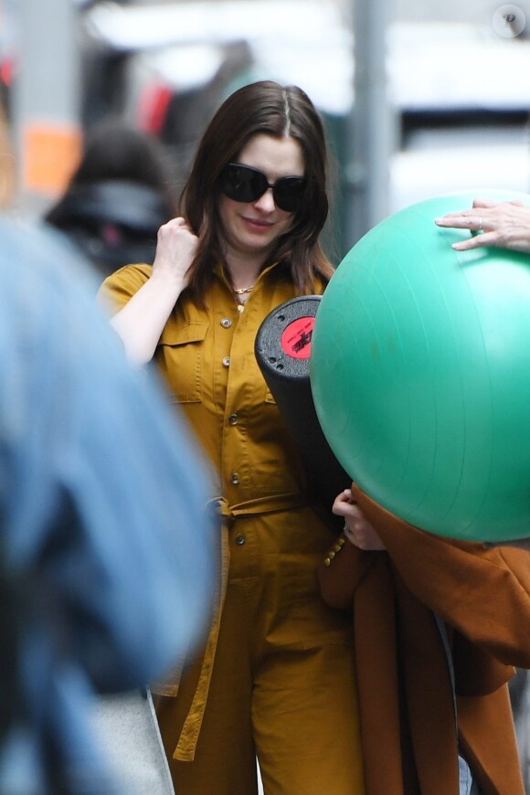 Exclusif - Anne Hathaway porte un tapis de yoga dans les rues du quartier de Upper West Side à New York. Anne est habillée avec une combinaison pantalon et porte un sac Chanel. Le 10 mars 2020.