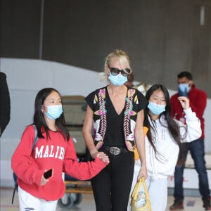 Laeticia Hallyday et ses filles Jade et Joy arrivent, avec des masques de protection contre l'épidémie de coronavirus (Covid-19), à l'aéroport de Paris-Charles-de-Gaulle à Roissy-en-France, France, le 18 juin 2020.