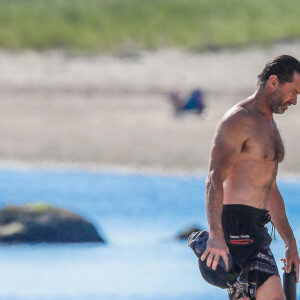 Exclusif - Hugh Jackman se balade sur la plage avec sa femme Deborra Lee Furness et ses chiens sous le soleil des Hamptons, le 25 juillet 2020