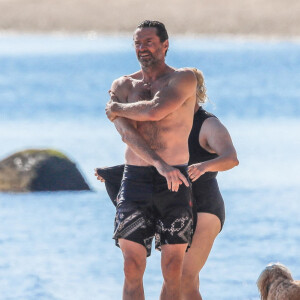 Exclusif - Hugh Jackman se balade sur la plage avec sa femme Deborra Lee Furness et ses chiens sous le soleil des Hamptons, le 25 juillet 2020