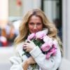 Celine Dion rayonnante et très souriante dans un ensemble pull écru et jupe bouffante fleurie salue ses fans à la sortie de son hôtel à New York, hiver 2020 