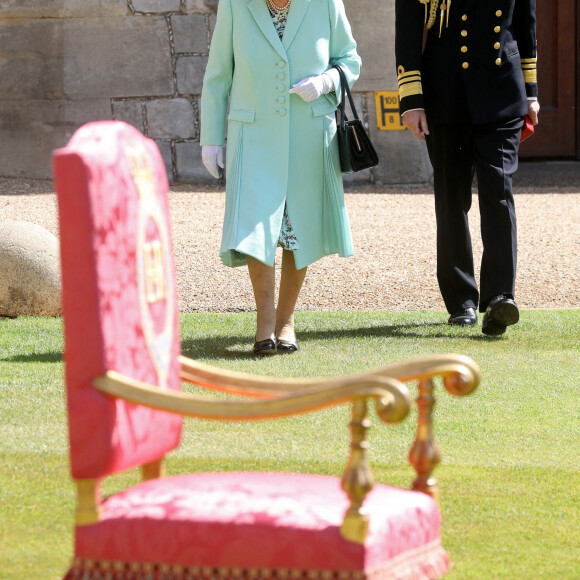 La reine Elisabeth II d'Angleterre remet au capitaine Thomas Moore son titre de chevalier lors d'une cérémonie au château de Windsor, le 17 juillet 2020.