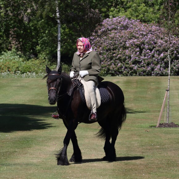 La reine Elisabeth II fait une balade à cheval dans le parc du château de Windsor le 31 mai 2020.