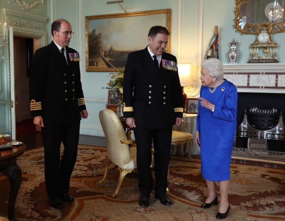 La reine Elisabeth II d'Angleterre reçoit le contre-amiral Stephen Moorhouse et le capitaine Angus Essenhigh au palais de Buckingham le 18 mars 2020 à Londres.