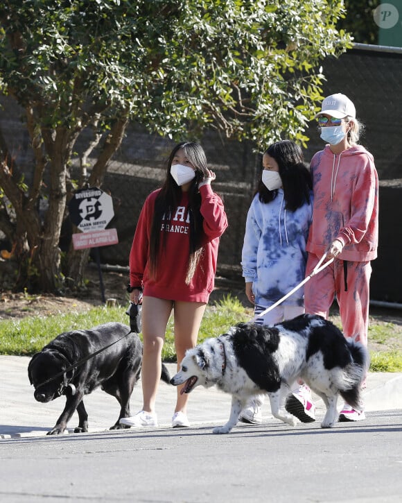 Laeticia Hallyday, ses filles Jade et Joy, avec des masques, et leurs chiens Santos, Cheyenne et Bono se promènent dans le quartier de Pacific Palisades, à Los Angeles, Californie, Etats-Unis, le 3 avril 2020, pendant la période de confinement.