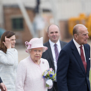 La reine Elisabeth II d'Angleterre et le prince Philip, duc d'Edimbourg visitent avec leur petit-fils prince William, duc de Cambridge, la nouvelle base East Anglian Air Ambulance à l'aéroport de Cambridge où il travaille à Cambridge, le 13 juillet 2016.