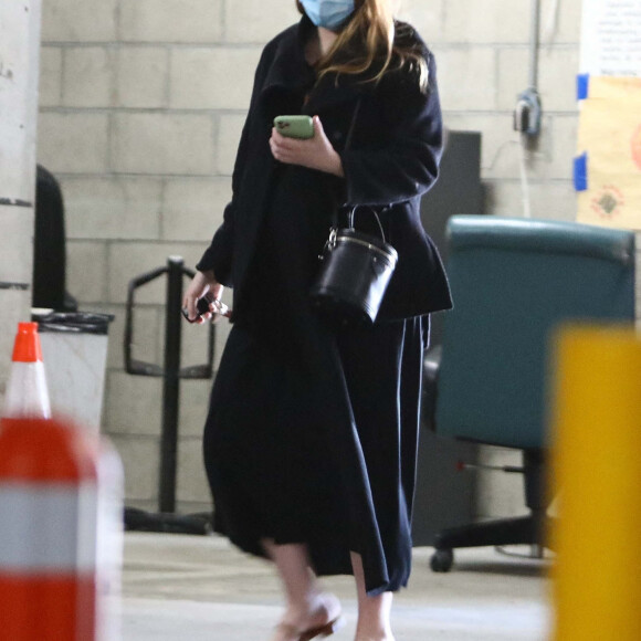 Exclusif - Emma Stone (enceinte) rejoint sa voiture dans un parking, après avoir fait du shopping dans les rues de Santa Monica. Le 4 mars 2021.