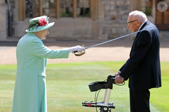 La reine Elizabeth II d'Angleterre remet au capitaine Thomas Moore son titre de chevalier lors d'une cérémonie au château de Windsor, le 17 juillet 2020.
