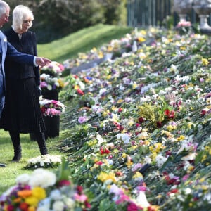 Le prince Charles, prince de Galles et la duchesse de Cornouailles Camila Parker-Bowles passent en revue les hommages au prince Philip dans les jardins de Marlborough House à Londres le 15 avril 2021.